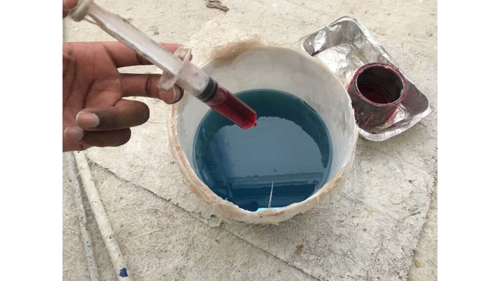 Fiberglass boat leak repair - Close up hand mixing resin and hardener