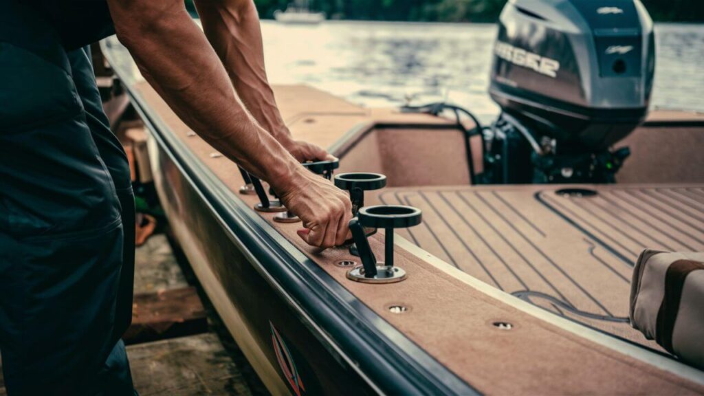 someone adjusting rod holders on a boat