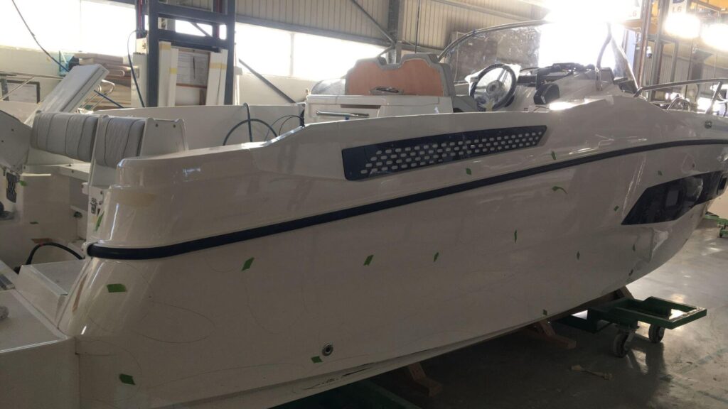 a fiberglass boat during maintenance inside a factory