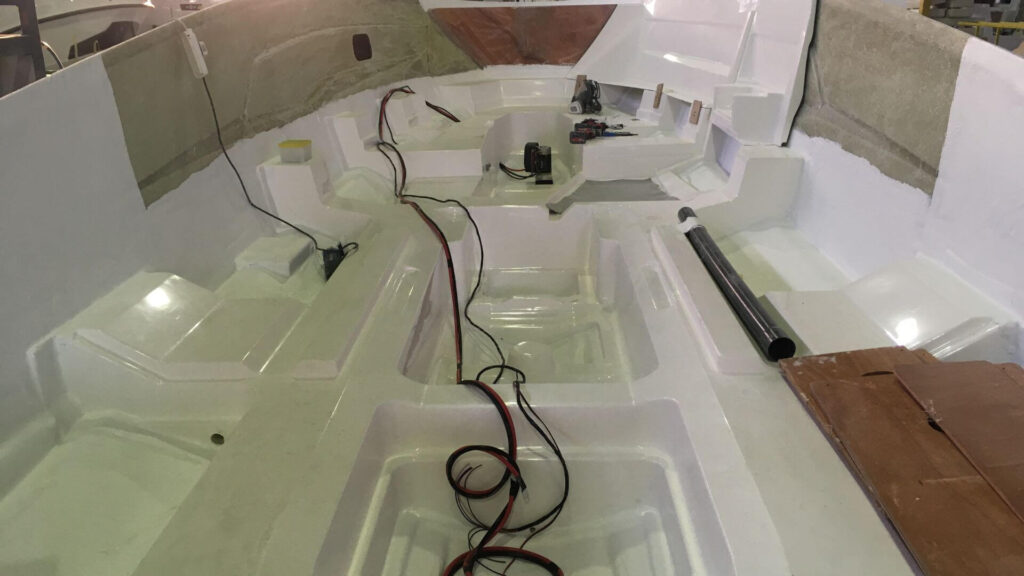 fully structural fiberglass stringer being mounted inside the boat hull